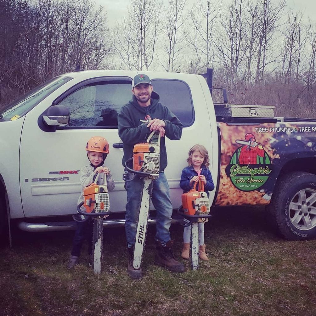 owner standing with his children in front of branded truck